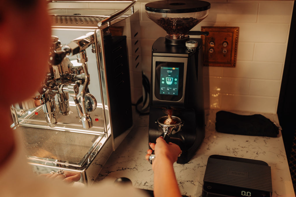 Grinding coffee on a LUCCAQ Atom 75 espresso grinder lifestyle by clive coffee