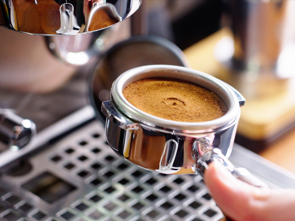 upclose shot of an espresso puck with a dent from the dispersion screen in the center lifestyle by clive coffee