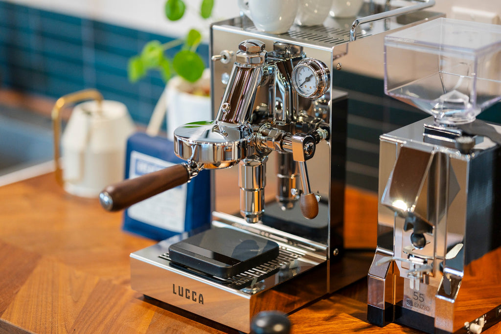 profile shot of the LUCCA Solo espresso machine in stainless steel lifestyle by clive coffee