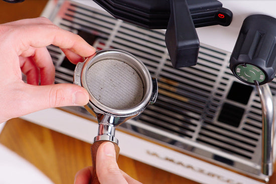 talent placing a metal puck screen in a portafilter lifestyle by clive coffee